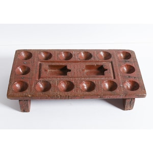 Antique India Pallankuzhi Mancala game board. Carved and painted wooden Pallanguzhi.