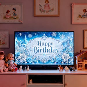 May include: A television screen displays a "Happy Birthday" message with a winter theme, surrounded by blue and white floral designs and snowflakes. The TV sits on a pink and white cabinet, with dolls and miniature figurines.