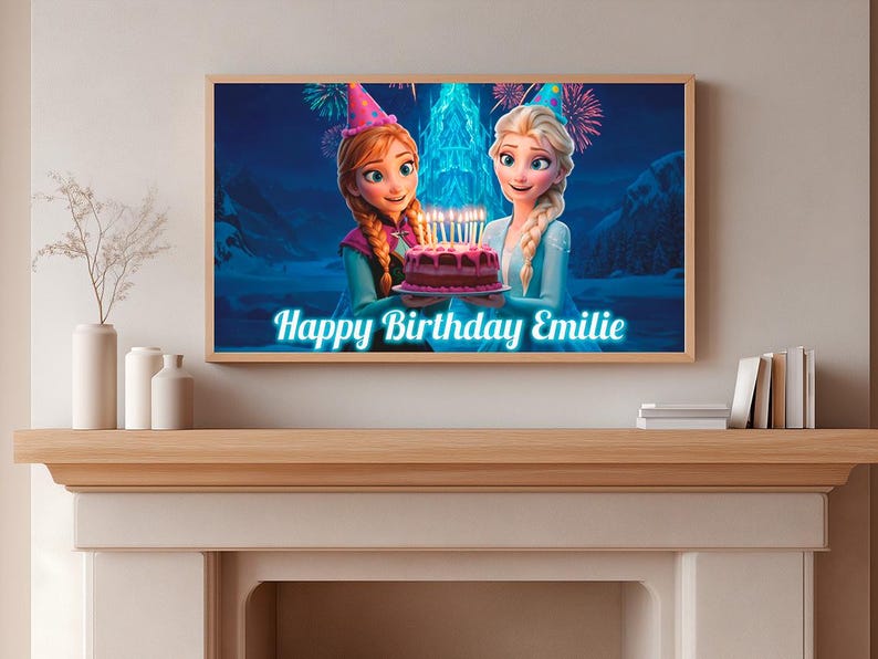 May include: A framed print featuring animated characters from the movie Frozen holding a birthday cake with lit candles. The text "Happy Birthday Emilie" is displayed in a blue font. The print is displayed on a wooden mantel.