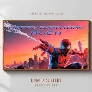 Puede incluir: Impresión artística digital enmarcada de Spider-Man lanzando su telaraña. Las palabras "HAPPY BIRTHDAY ALEX" están en azul y blanco. El fondo muestra un paisaje urbano al atardecer. El marco es de color marrón claro.