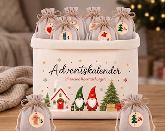 May include: A white fabric storage bin featuring the text Adventskalender 24 kleine Überraschungen, decorated with illustrations of a house, two gnomes, and a Christmas tree. It contains several small beige drawstring bags with wooden tags.