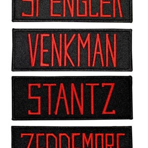 May include: Four rectangular black embroidered patches with red stitched lettering. The patches feature the names SPENGLER, VENKMAN, STANTZ, and ZEDDEMORE in a bold, sans-serif font. Each patch has a clean, finished border and a flat, fabric texture.