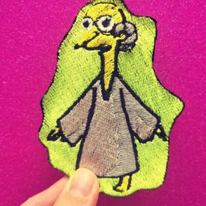 May include: A white ceramic mug with a black handle and the text "But First, Coffee" in a black, bold font. The mug is on a white surface.