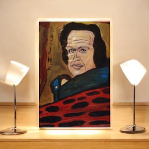 Puede incluir: Un retrato artístico de un hombre con cabello oscuro y una prenda azul y roja estampada. La pintura tiene un fondo amarillo y marrón con el nombre "BAZILH" escrito verticalmente a la izquierda. La obra de arte se exhibe sobre una superficie de madera, flanqueada por dos lámparas modernas.