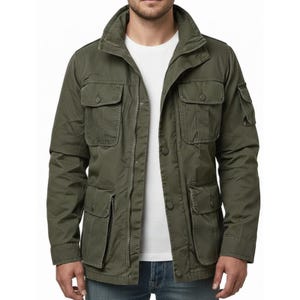 Puede incluir: Chaqueta de campo verde oliva con múltiples bolsillos delanteros, cierre de botones y cuello alzado. La chaqueta tiene un diseño casual y utilitario, adecuado para actividades al aire libre. La chaqueta la lleva una persona con una camiseta blanca.