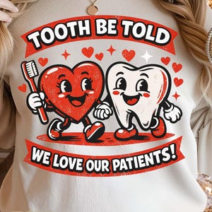 Puede incluir: Sudadera color crema con un gráfico que presenta un corazón rojo sosteniendo un cepillo de dientes y un diente sonriente. El texto "TOOTH BE TOLD WE LOVE OUR PATIENTS!" se muestra en rojo y blanco.