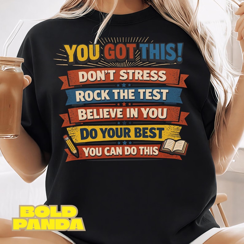 May include: Black sweatshirt with the text "YOU GOT THIS!" in yellow and blue. The design includes the phrases "DON'T STRESS", "ROCK THE TEST", "BELIEVE IN YOU", "DO YOUR BEST", and "YOU CAN DO THIS". A pencil and book graphic are also included.
