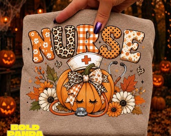 May include: A heathered tan t-shirt featuring the word NURSE in patterned letters above a pumpkin wearing a nurse cap and bow, decorated with a stethoscope, autumn leaves, and flowers. The design includes leopard print and plaid accents.
