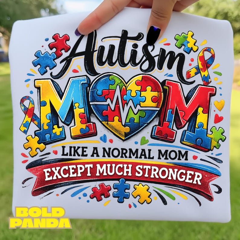 May include: White t-shirt with the words "Autism Mom" in colorful puzzle piece letters and a heart-shaped puzzle design. The shirt also has the text "Like a normal mom except much stronger" in a banner.