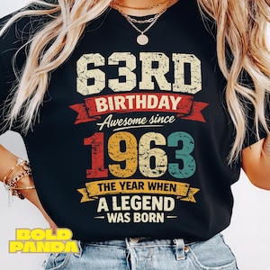 以下が含まれることがあります： 63歳の誕生日を祝う、かすれたデザインの黒いTシャツ。「63RD BIRTHDAY Awesome since 1963 The year when a legend was born」の文字が白、赤、黄色、ティールでプリントされています。
