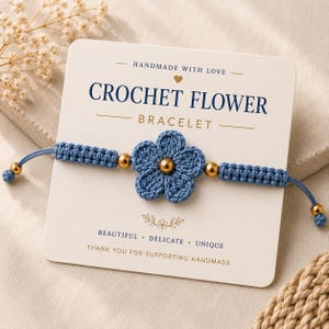 Peut inclure: Un bracelet fleur en crochet bleu avec des perles dorées. Le bracelet présente une fleur bleue faite à la main au centre, avec des détails en macramé bleu assortis et des perles dorées. La carte indique "CROCHET FLOWER BRACELET" et "HANDMADE WITH LOVE."