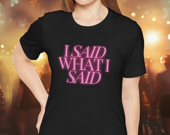 Puede incluir: Una camiseta negra con el texto "I SAID WHAT I SAID" en letras de neón rosa.