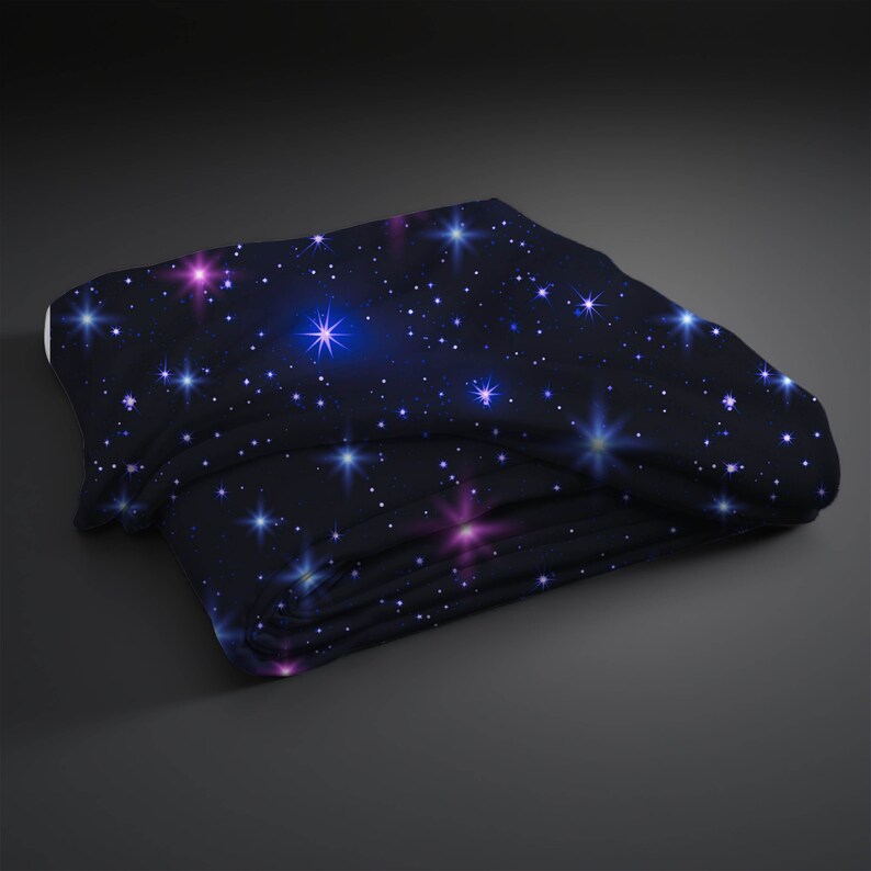 Puede incluir: Una s&aacute;bana de cama azul oscuro con estampado de galaxia con estrellas blancas, azules y rosas.