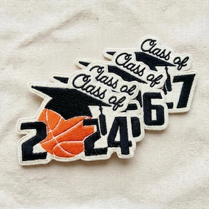 May include: Embroidered patches with the text "Class of" above the graduation year. The patches feature a black graduation cap and an orange basketball. The years 2024, 2026, and 2027 are visible.