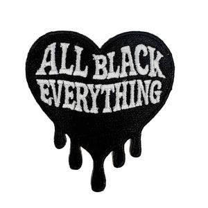 May include: Black heart-shaped patch with white embroidered text reading "ALL BLACK EVERYTHING." The bottom of the heart has a dripping effect. The patch is likely for clothing or accessories.