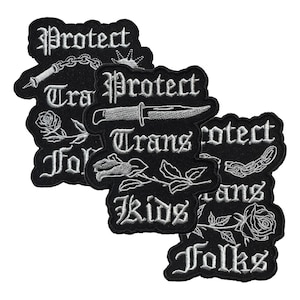 May include: A collection of black embroidered patches with white text and illustrations. The patches feature phrases like "Protect Trans Kids Folks" and images of a dagger, chain, and roses. The patches are designed for clothing or accessories.