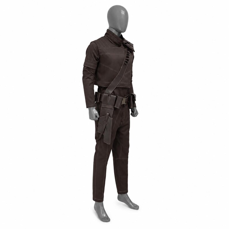 May include: A brown costume displayed on a mannequin. The outfit includes a jacket, pants, belt with pouches, and a shoulder strap. The jacket has long sleeves and a high collar. The pants are straight-legged. The costume is made of a dark brown material.