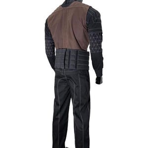 May include: A black long-sleeved shirt with a white geometric grid pattern on the sleeves, paired with a brown vest and a black tactical belt. The outfit includes black trousers featuring prominent white stitching along the seams and leg panels.