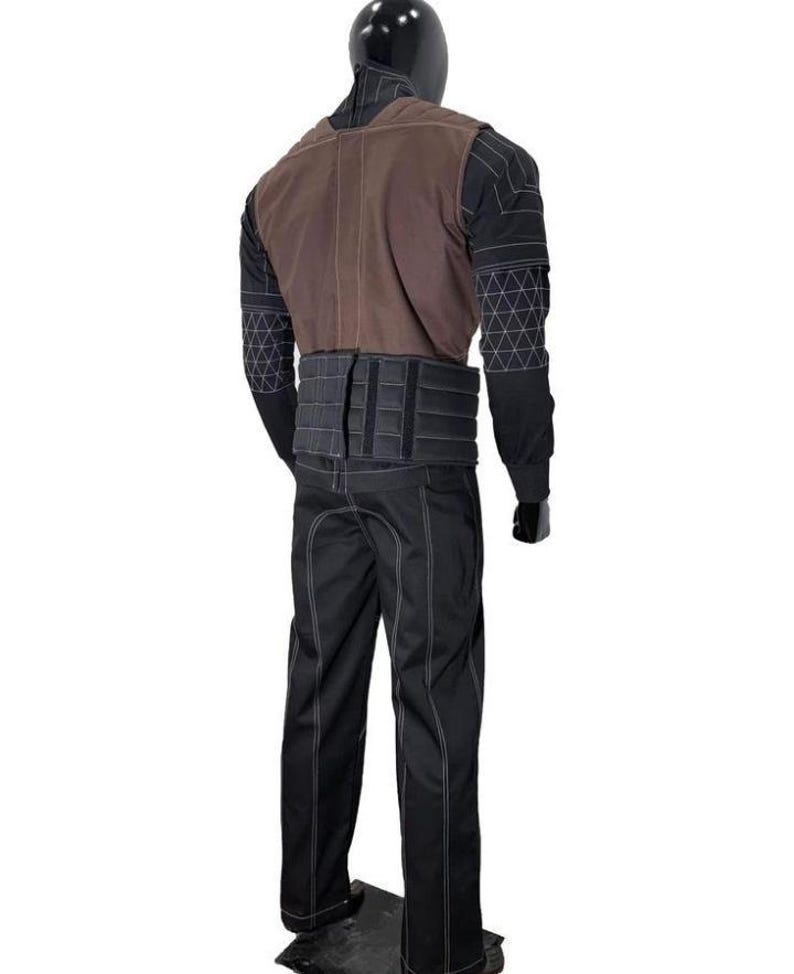 May include: A black long-sleeved shirt with a white geometric grid pattern on the sleeves, paired with a brown vest and a black tactical belt. The outfit includes black trousers featuring prominent white stitching along the seams and leg panels.
