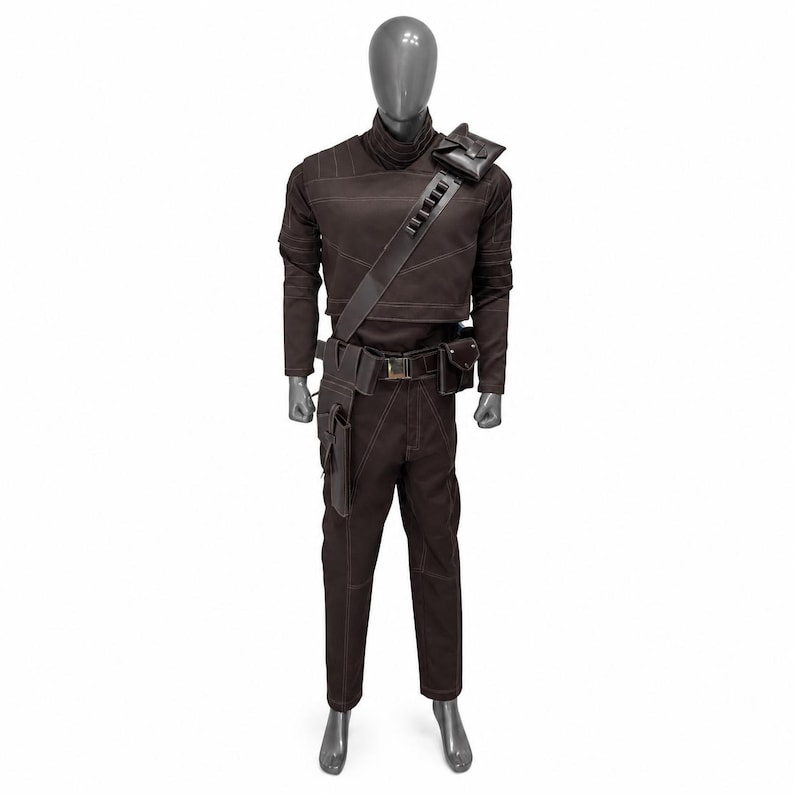 May include: Brown costume with a high collar, long sleeves, and matching pants. The outfit includes a shoulder bag, belt with pouches, and a strap across the chest. White stitching accents the seams. The costume is displayed on a mannequin.