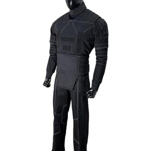 May include: Black tactical suit with white stitching, displayed on a mannequin. The suit includes a long-sleeved top, pants, and a high collar. The design features reinforced panels and a streamlined silhouette, suitable for various activities.