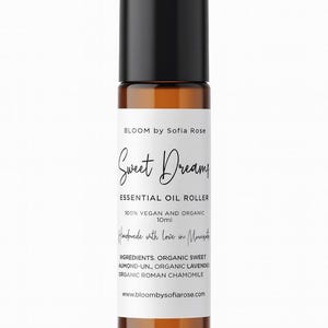 May include: A brown glass essential oil roller bottle with a black cap. The label reads "Sweet Dreamy" and lists ingredients. The bottle contains 10ml of product and is vegan and organic.