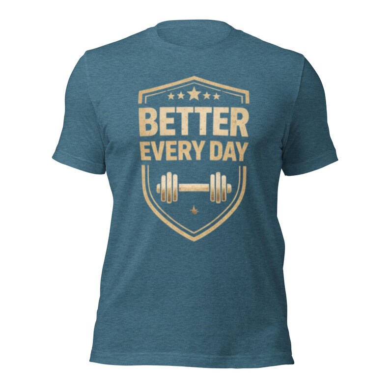 May include: A blue t-shirt with a gold shield design. The shield features the text "BETTER EVERY DAY" above a barbell illustration. The shirt is made of a soft material and has short sleeves.