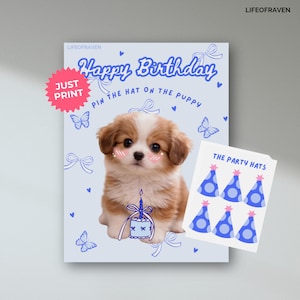 May include: A light blue birthday card featuring a puppy illustration, the text "Happy Birthday", and "Pin the hat on the puppy". Includes a sheet of blue party hats. A pink "Just Print" sticker is in the upper left.
