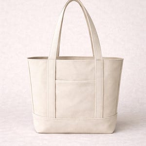 K&ouml;nnte beinhalten: Cremefarbene Tragetasche mit rechteckiger Form und zwei Griffen. Die Tasche hat eine Vordertasche und verst&auml;rkte N&auml;hte. Die neutrale Farbe und das schlichte Design machen sie zu einem vielseitigen Accessoire.