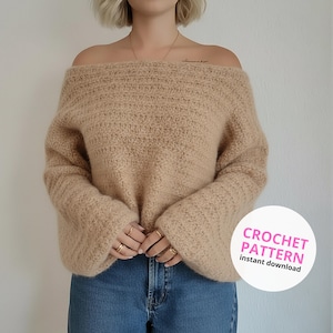 May include: A beige off-the-shoulder sweater with long sleeves. The sweater has a textured knit design and is paired with blue jeans. A white circle with pink text that reads "CROCHET PATTERN instant download" is in the lower right corner.