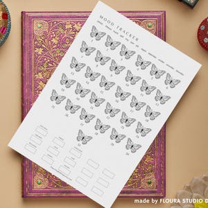 Puede incluir: Una taza de cerámica blanca con un asa negra y el texto "But First, Coffee" en negro, con una fuente de estilo manuscrito. La taza está sobre una superficie blanca.