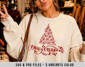 May include: A cream-colored crewneck sweatshirt featuring a red graphic of a Christmas tree decorated with bows and the text Merry Christmas in a cursive script. The design is centered on the chest of the long-sleeved garment.