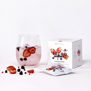 Könnte beinhalten: Ein Glas rosa Getränk mit Eis, Erdbeeren und Blaubeeren. Eine weiße Schachtel mit "SECCO Drink Infusion Pepper Berry" und ein Päckchen davon liegen neben dem Glas. Erdbeeren und Blaubeeren sind davor verstreut.