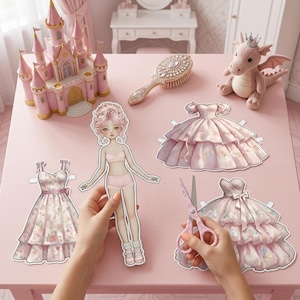 Printable paper doll in Pinky Princess style on a desk. Features a 16cm doll with royal pink gowns, tiaras, and cute accessories. Part of a 500+ piece aesthetic mega pack. Perfect for princess-themed crafts, journaling, and DIY paper toys. High-resolution Pinterest aesthetic paper craft.