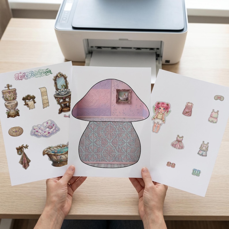 May include: Three printed sheets featuring a paper doll set titled Fairy Bathroom. The sheets include a mushroom-shaped room backdrop with patterned walls, various bathroom furniture stickers, a fairy character, and several clothing items.