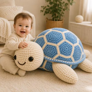 May include: A large, round, crocheted turtle plush toy featuring a cream-colored head and limbs, with a shell composed of blue hexagonal segments outlined in cream yarn. The turtle has two large, smooth, black circular eyes and a stitched smile.