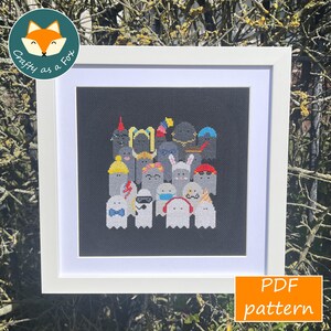 May include: A framed cross-stitch pattern featuring a group of whimsical ghosts, each adorned with unique accessories like hats and bow ties, against a black background. The artwork is presented in a white frame, with the text "PDF pattern" in the lower right corner.