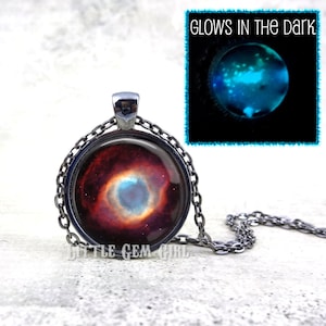 May include: A silver necklace with a round pendant featuring a colorful image of the Orion Nebula. The pendant glows in the dark.