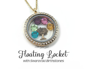 May include: Gold chain necklace with a round floating locket. The locket has a clear glass face with a small tree charm and five colorful birthstones inside. The text "Little Gem Girl" and "Floating Locket with Swarovski Birthstones" is printed below the locket.