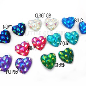May include: Assortment of 10 heart-shaped iridescent rhinestones in various colors, including clear, pink, purple, blue, green, aqua, and navy.  The rhinestones have a faceted, textured design.