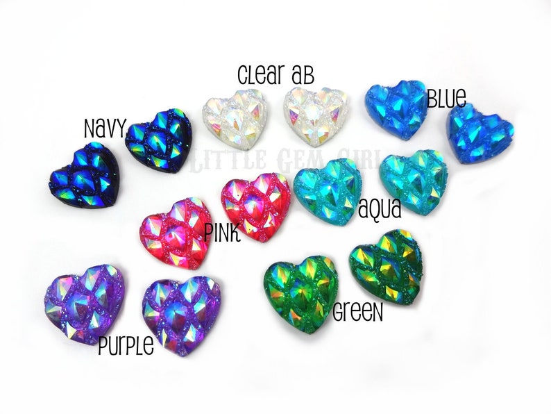 May include: Assortment of 10 heart-shaped iridescent rhinestones in various colors, including clear, pink, purple, blue, green, aqua, and navy.  The rhinestones have a faceted, textured design.
