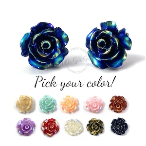 May include: A pair of blue rose stud earrings with a gold center.  Pick your color!  The image shows 10 different color options for the rose earrings: cream, light blue, light pink, pink, orange, purple, red, white, gold, and black.