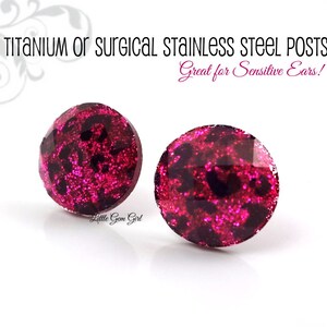 May include: A pair of pink glitter stud earrings with a black leopard print design. The earrings are made with titanium or surgical stainless steel posts, which are great for sensitive ears.