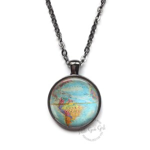 May include: A silver chain necklace with a round glass pendant featuring a vintage world map. The map is in shades of blue, green, yellow, and red. The pendant is surrounded by a silver frame.