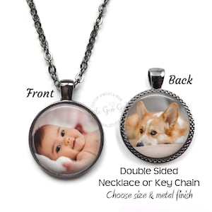 May include: Double-sided necklace or keychain with a silver chain. The front features a photo of a baby, and the back features a photo of a corgi dog.