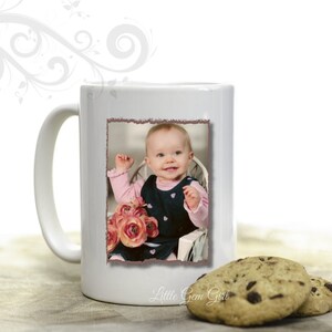 May include: White ceramic mug with a photo of a baby girl in a pink and black dress holding a bouquet of pink flowers. The mug has the text "Little Gem Girl" printed on the bottom.