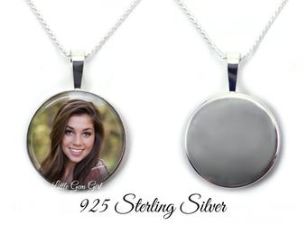 May include: A 925 sterling silver pendant necklace featuring a circular frame. One side displays a photographic portrait of a smiling person with long brown hair, while the reverse side is a plain, polished silver surface. The text Little Gem Girl is visible.