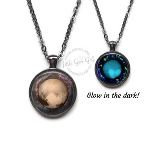 May include: Two necklaces with round glass pendants. One pendant features a photo of Pluto, the other pendant glows in the dark and features a blue and green nebula. The necklaces are on a white background.  "Custom Jewelry & More Little Gem Girl Personalized for You" is written on a circle in the background.
