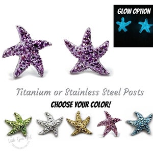 May include: A pair of purple starfish earrings with crystal accents. The earrings are available in a variety of colors, including green, silver, gold, pink, and blue. The earrings are made with titanium or stainless steel posts. The earrings can glow in the dark.