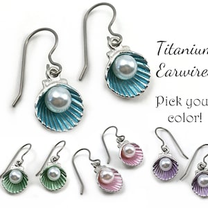 May include: Titanium earrings with a pearl in a seashell design. Choose from turquoise, green, pink, or purple.